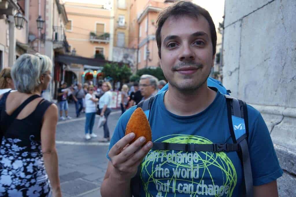 Dans les rues de Taormina, Sicile, Italie François et un arancino, dans la grand rue de Taormina